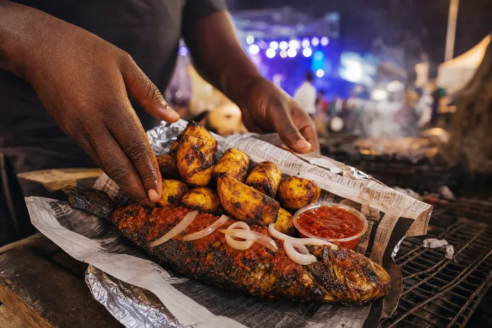 Close-up of roasted plantain and grilled fish with pepper sauce at a Port Harcourt food stall.