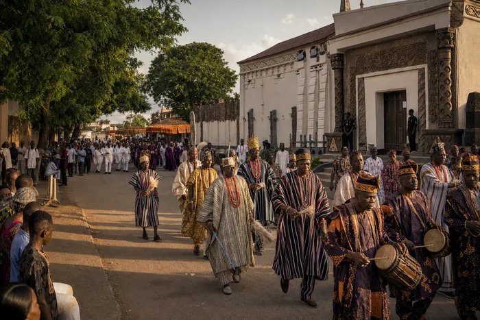A respectful public procession in Owo with drummers, richly dressed participants and palace-facing community activity.